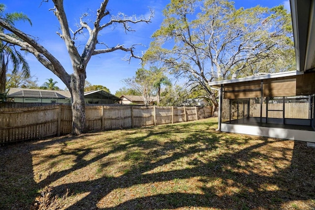 view of yard featuring a fenced backyard and a sunroom