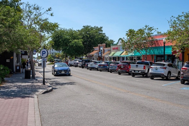 view of road featuring street lights, curbs, and sidewalks