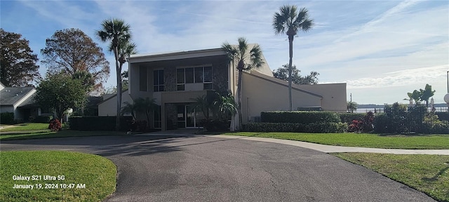 view of front of home with a front lawn, fence, and stucco siding