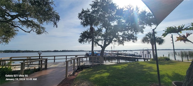 dock area with a water view and a yard