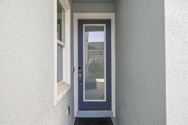 doorway to property with stucco siding