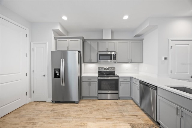 kitchen with light countertops, appliances with stainless steel finishes, gray cabinets, and recessed lighting