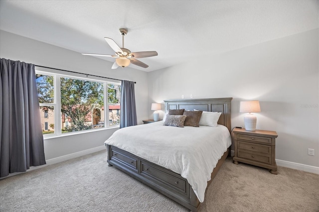 bedroom with light colored carpet, ceiling fan, and baseboards