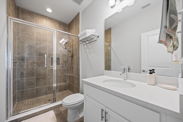 bathroom with visible vents, toilet, a stall shower, vanity, and tile patterned floors