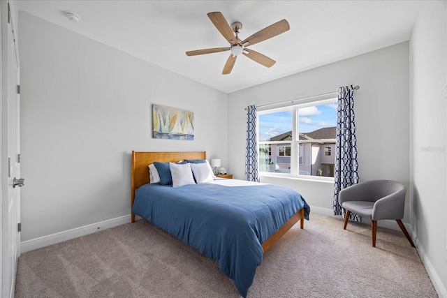 bedroom featuring light carpet, a ceiling fan, and baseboards