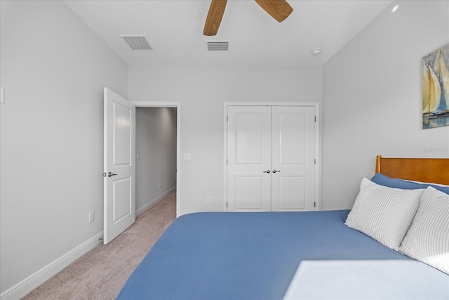 bedroom featuring baseboards, a closet, visible vents, and light colored carpet