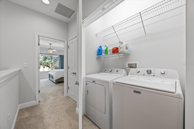 clothes washing area with light colored carpet, laundry area, visible vents, baseboards, and washer and dryer