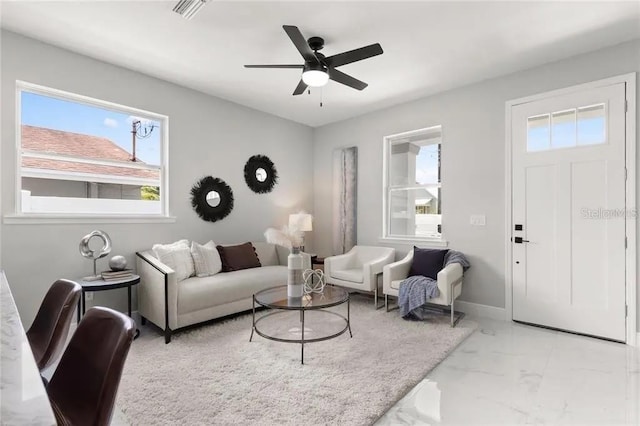 living room with marble finish floor, baseboards, visible vents, and a ceiling fan