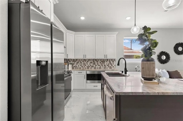 kitchen with marble finish floor, stainless steel appliances, tasteful backsplash, a sink, and an island with sink