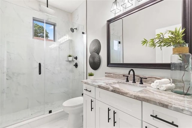 bathroom featuring marble finish floor, vanity, a marble finish shower, and toilet