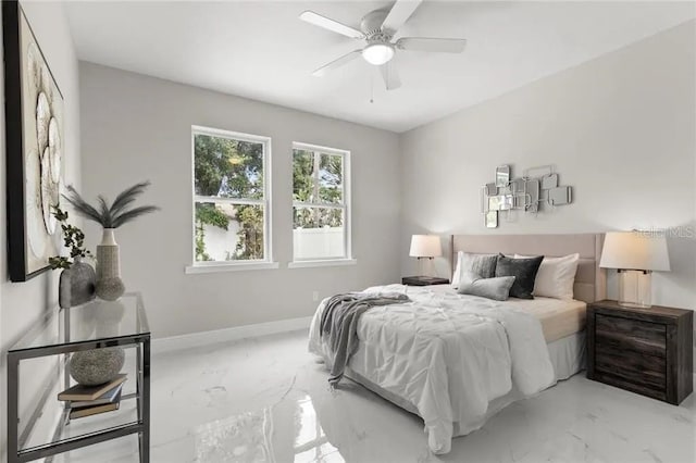 bedroom with ceiling fan, marble finish floor, and baseboards