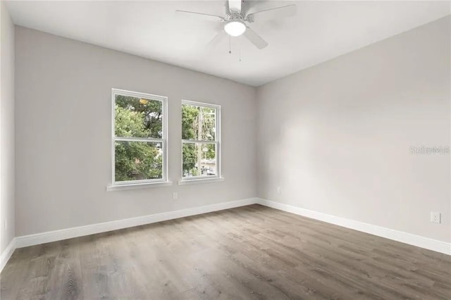 spare room featuring ceiling fan, baseboards, and wood finished floors