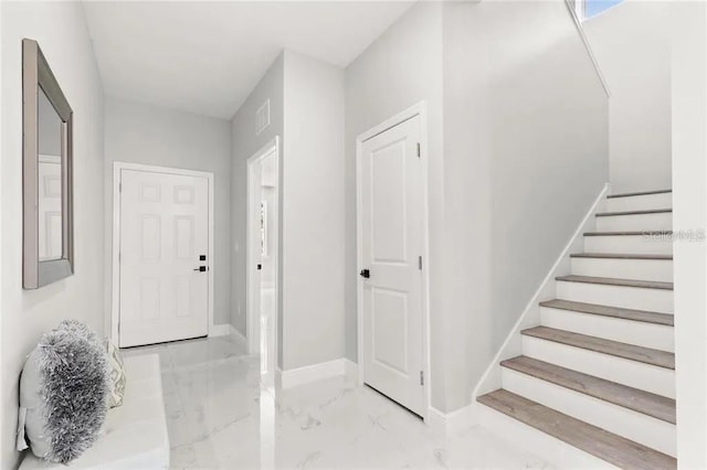 entryway featuring marble finish floor, visible vents, stairway, and baseboards