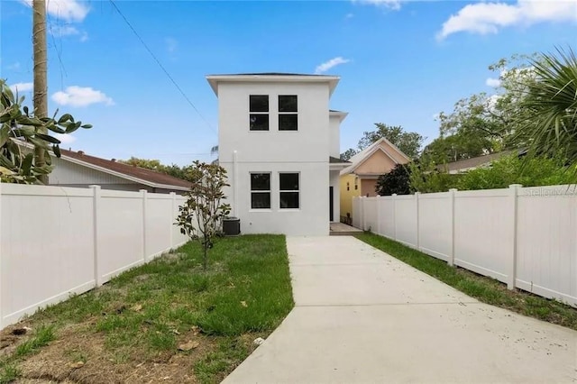 rear view of house with stucco siding, a lawn, a patio area, cooling unit, and a fenced backyard