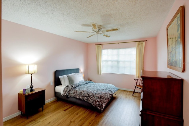 bedroom featuring ceiling fan, wood finished floors, and baseboards