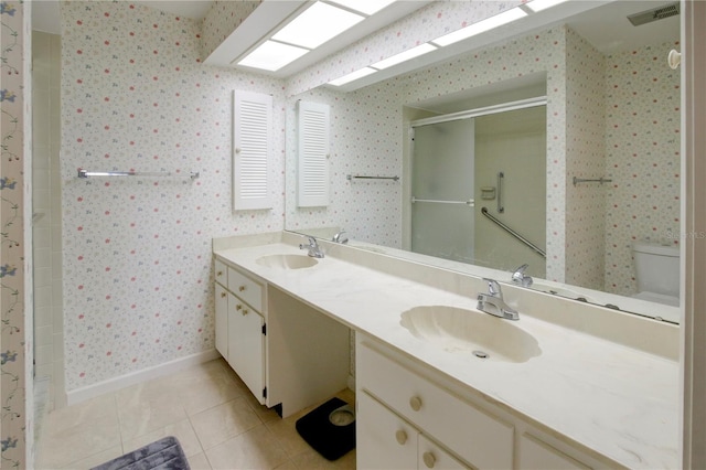 bathroom with tile patterned floors, a sink, and wallpapered walls