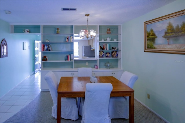 dining space with baseboards, tile patterned flooring, visible vents, and a notable chandelier