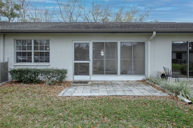 back of house featuring a yard, central AC unit, a patio area, and stucco siding