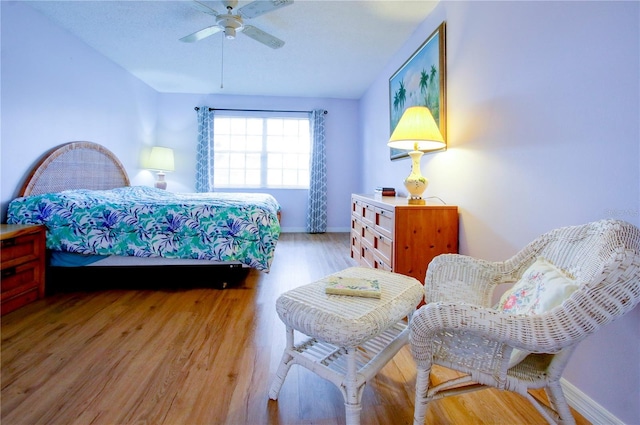 bedroom with light wood-style floors, ceiling fan, and baseboards