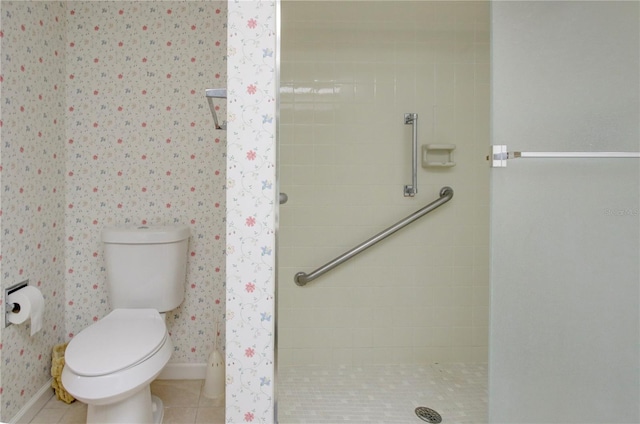 full bathroom with wallpapered walls, a stall shower, baseboards, toilet, and tile patterned floors