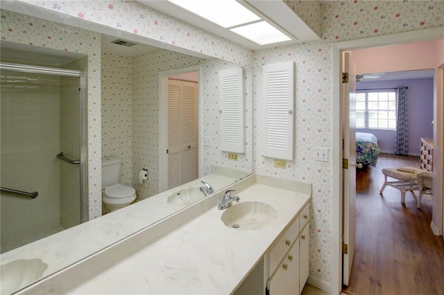 ensuite bathroom with wood finished floors, visible vents, and wallpapered walls