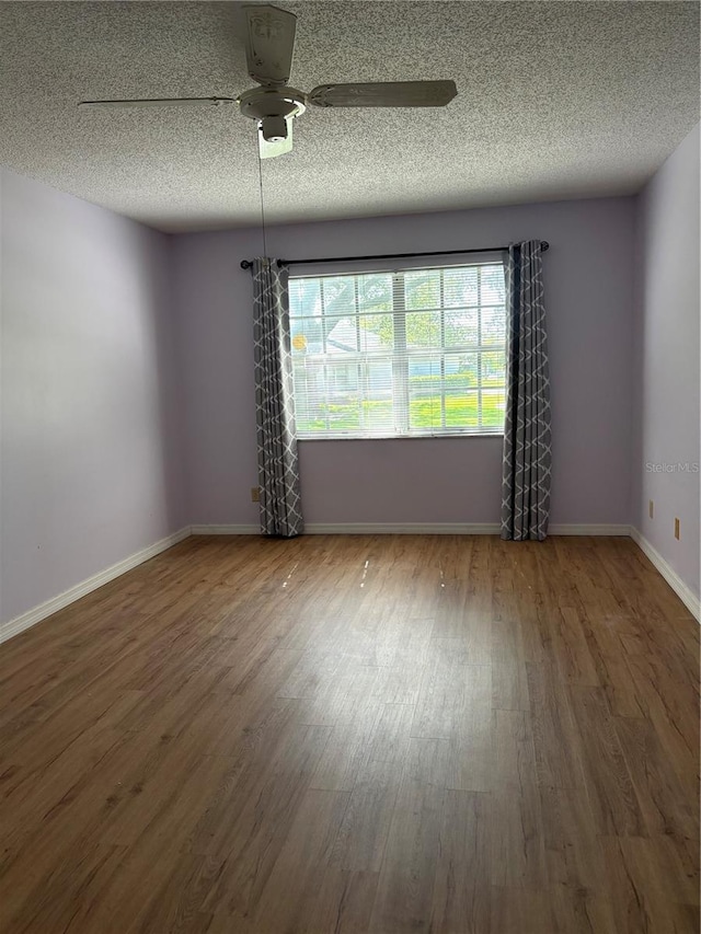 860 Glen More Ct Unit B, Palm Harbor, FL 34684 - spare room with baseboards, a ceiling fan, a textured ceiling, and wood finished floors