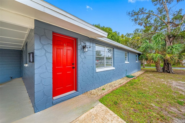 view of exterior entry featuring a yard