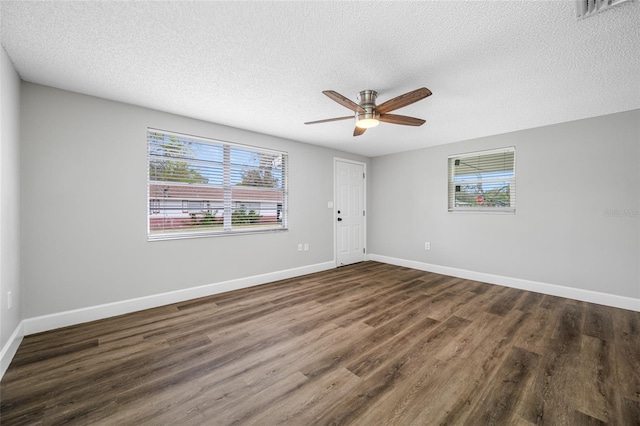 unfurnished room featuring baseboards, visible vents, and dark wood finished floors