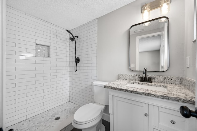 full bath featuring a textured ceiling, toilet, a shower stall, and vanity