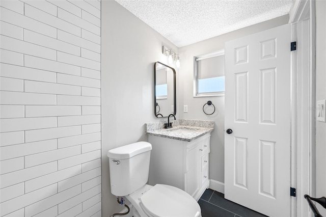 full bathroom featuring toilet, tile patterned flooring, a textured ceiling, and vanity