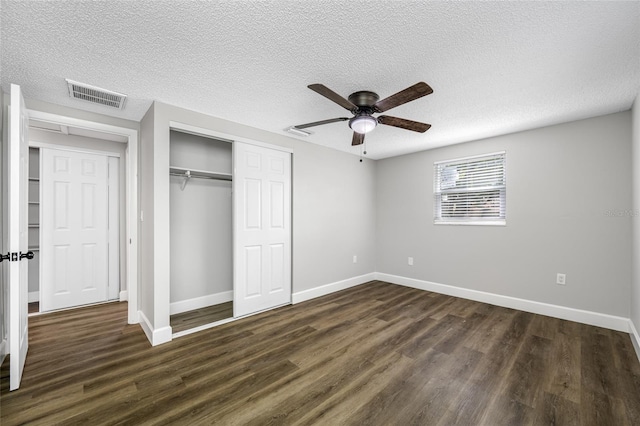 unfurnished bedroom with baseboards, a closet, visible vents, and dark wood-type flooring