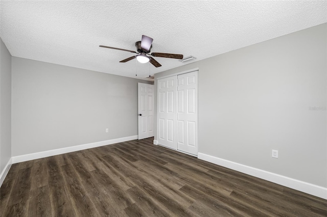 unfurnished bedroom with a closet, visible vents, baseboards, and dark wood-style flooring