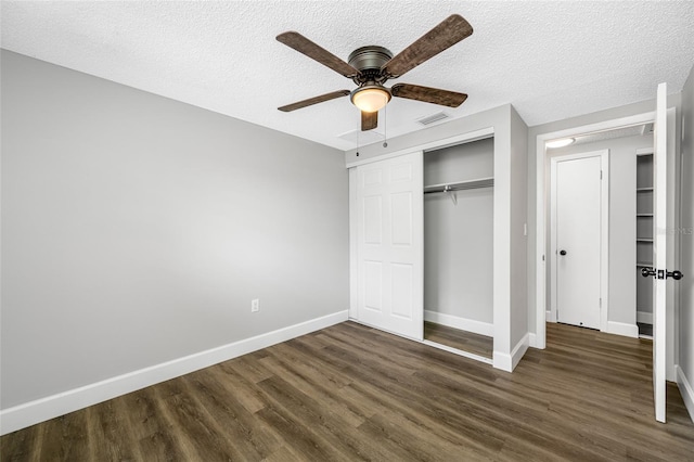 unfurnished bedroom with a textured ceiling, visible vents, baseboards, a closet, and dark wood finished floors