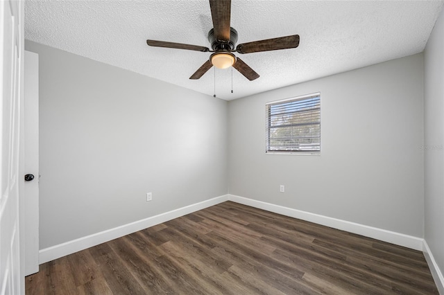 spare room with dark wood-type flooring, ceiling fan, a textured ceiling, and baseboards