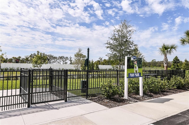 view of gate featuring a lawn and fence