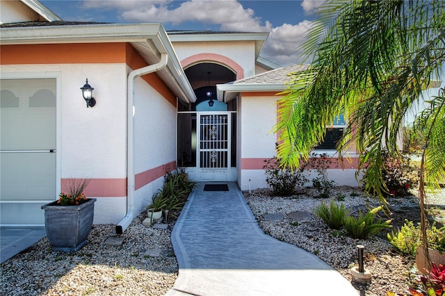 view of exterior entry featuring stucco siding and an attached garage