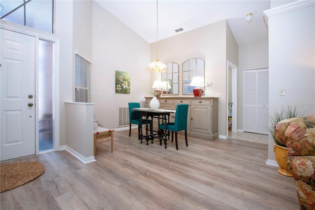 dining area with visible vents, high vaulted ceiling, wood finished floors, baseboards, and a chandelier