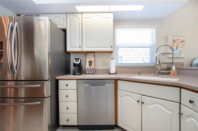 kitchen featuring a sink, light countertops, white cabinets, and stainless steel appliances