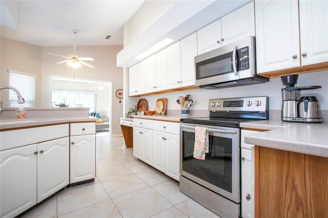 kitchen with a sink, stainless steel appliances, white cabinetry, and light countertops