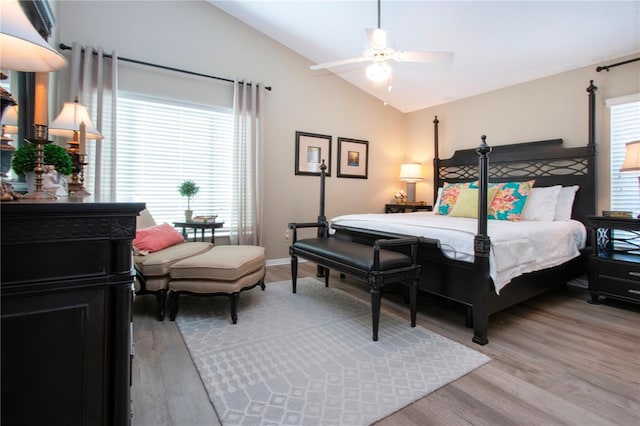 bedroom with multiple windows, a ceiling fan, light wood-style floors, and lofted ceiling