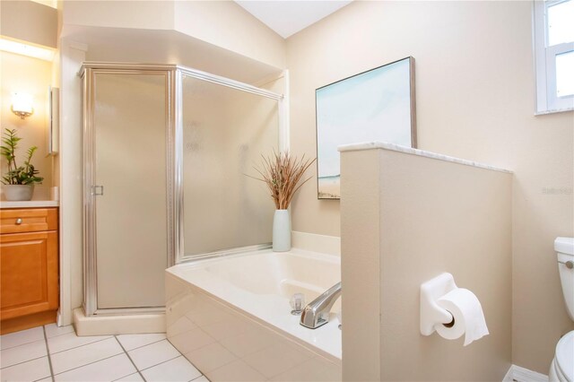 bathroom featuring vanity, a bath, a shower stall, tile patterned floors, and toilet