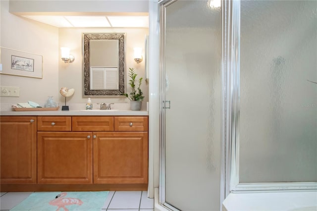 bathroom with tile patterned flooring, a shower stall, and vanity