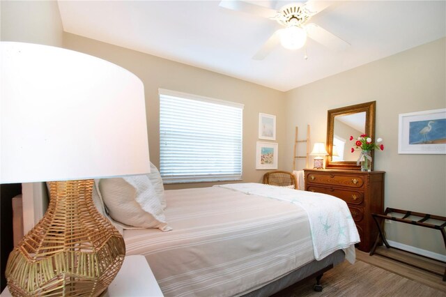 bedroom with multiple windows, wood finished floors, and a ceiling fan