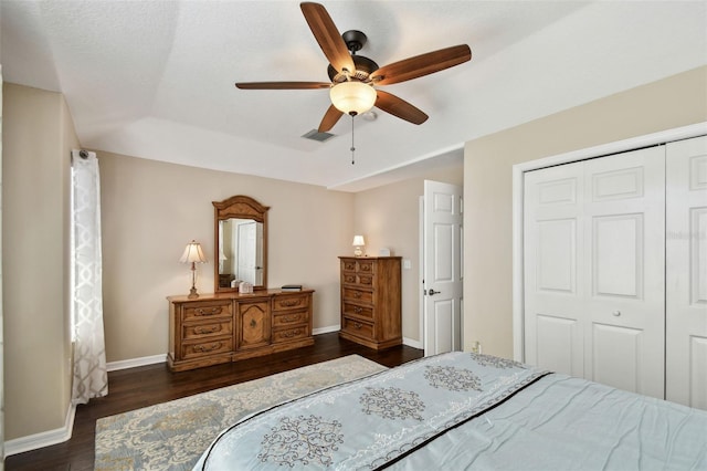 bedroom featuring dark wood-style flooring, a ceiling fan, visible vents, baseboards, and a closet