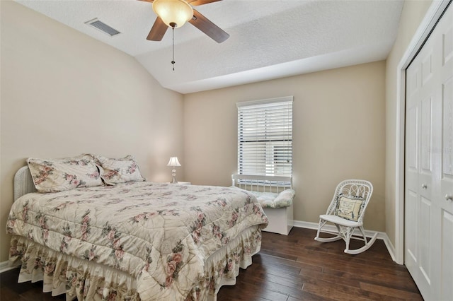 bedroom featuring baseboards, visible vents, lofted ceiling, dark wood-style floors, and a closet