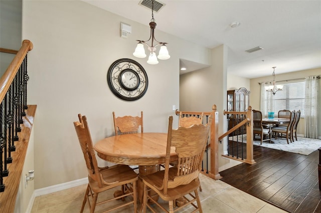 dining room with a chandelier, visible vents, and baseboards