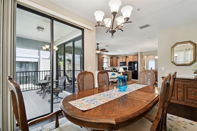 dining space featuring light wood-type flooring, recessed lighting, visible vents, and ceiling fan with notable chandelier