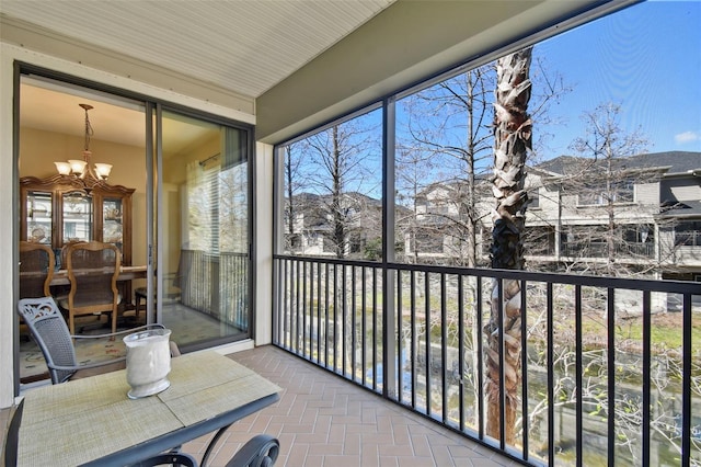 sunroom / solarium featuring a chandelier