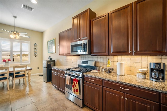 kitchen with light tile patterned floors, visible vents, decorative backsplash, appliances with stainless steel finishes, and baseboards