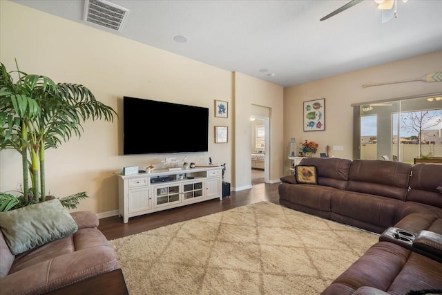 living area with dark wood-style floors, baseboards, visible vents, and a ceiling fan